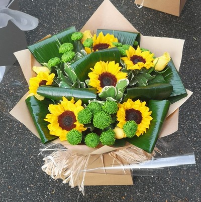 Sunflower Helianthus bouquet with rolled leaves and green chrysanthemum 