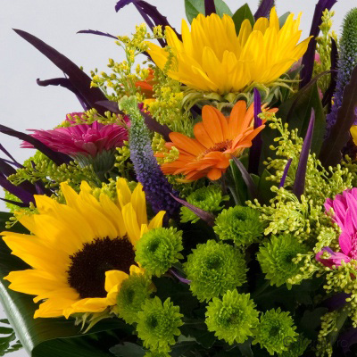 Pink yellow orange green flowers in a glass vase